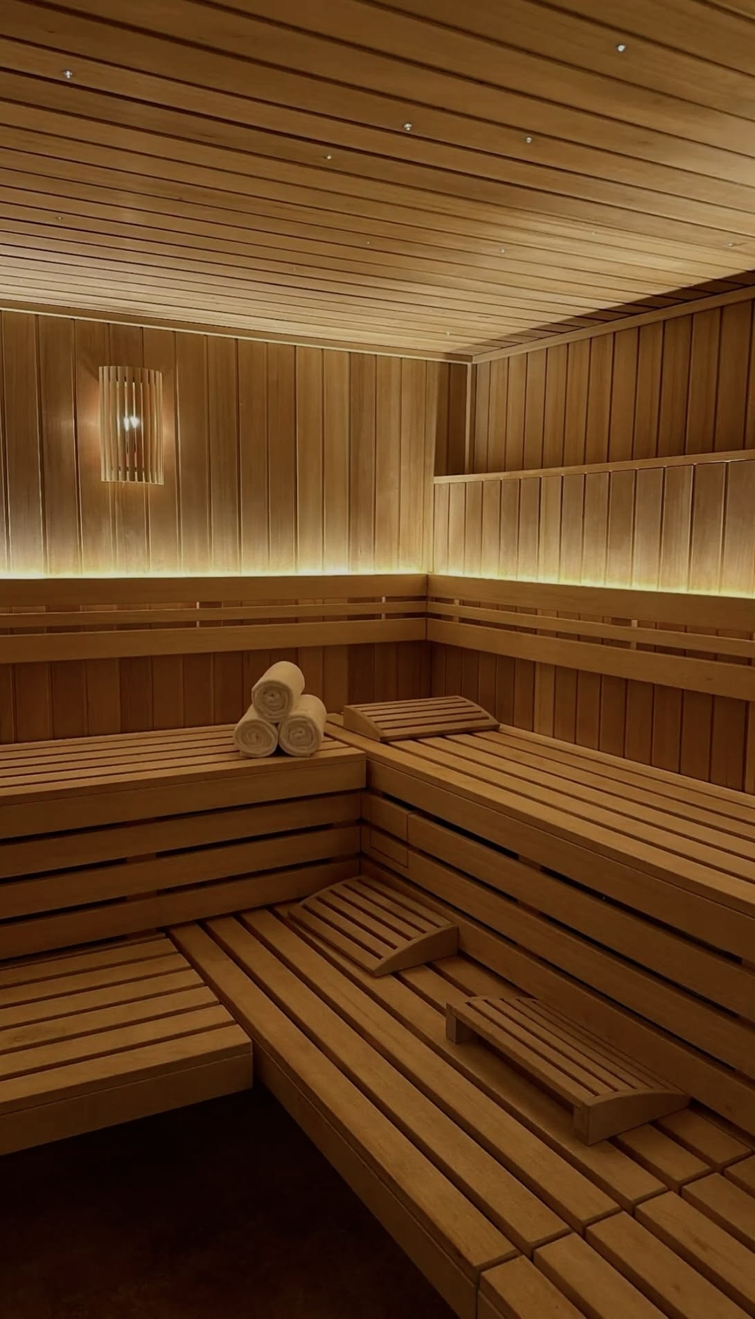 Fińska sauna z jasnego drewna z ciepłym podświetleniem
